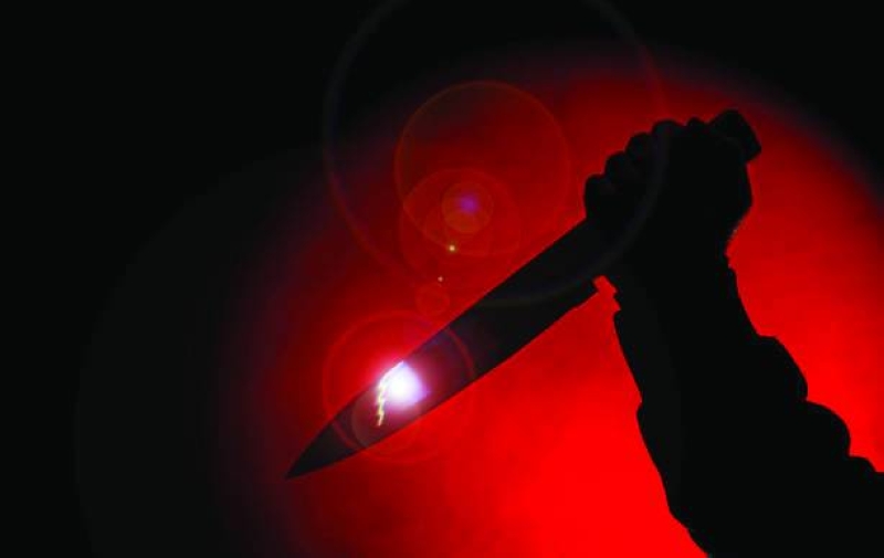 Shadow hand holds knife in darkness in red spot light with glows and lens flare