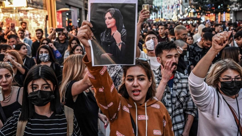 Caption: A protester holds a portrait of Mahsa Amini during a demonstration protesting her death at the hands of Iran's morality police PHOTO: AFP