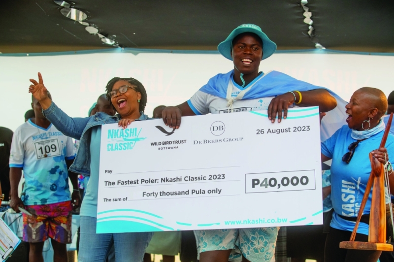 Lasty Kedisa receing his cheque for being Okavango Delta’s Fastest Poler