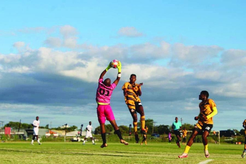 BR Highlanders goalkeeper (in pink) safely catches the ball to stop another Chadibe FC attack