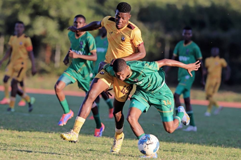 Title race: Lebogang Ogotseng (yellow) of Police XI tussling for the ball against Tlhalefo Kame (green) of Taung Young Strikers PIC: KENNEDY RAMOKONE