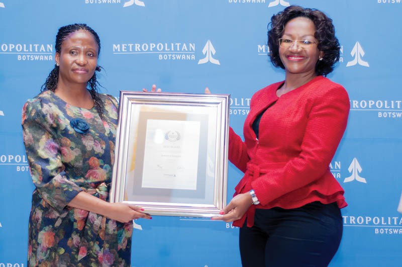 Jennifer Kobuoa (red top) receiving an award for hitting the million Pula mark