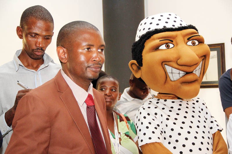 Mabijo cartoonist Tebogo Motswtla standing next to iconic cartoon dummy Mabijo