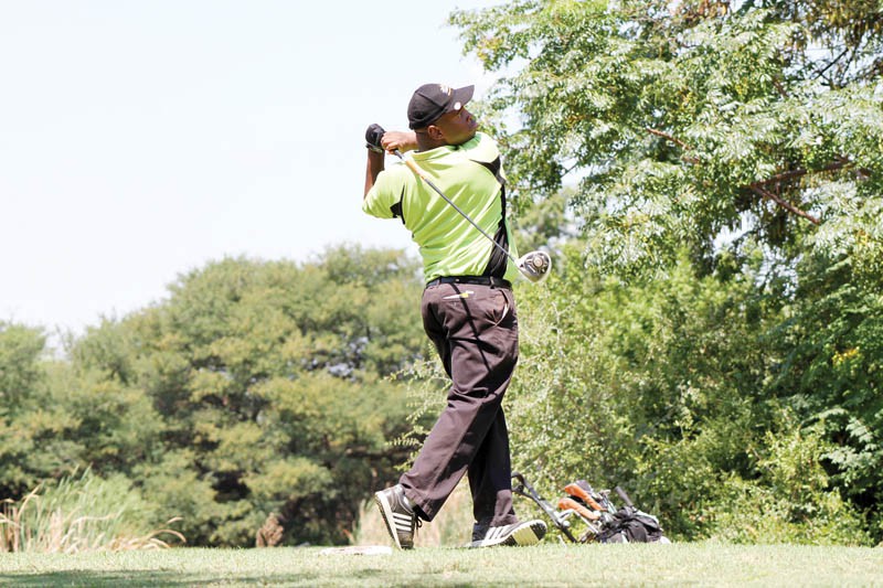 Emerging from the woods: a golfer plays a shot