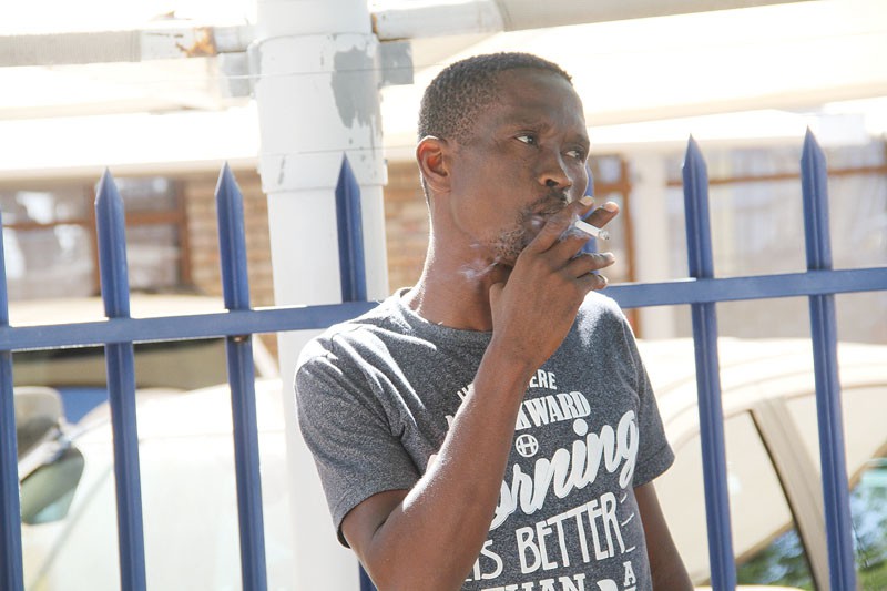 Puffing away stress: Alford Serumula taking a puff before his mention in court. PICS: KENNEDY RAMOKONE