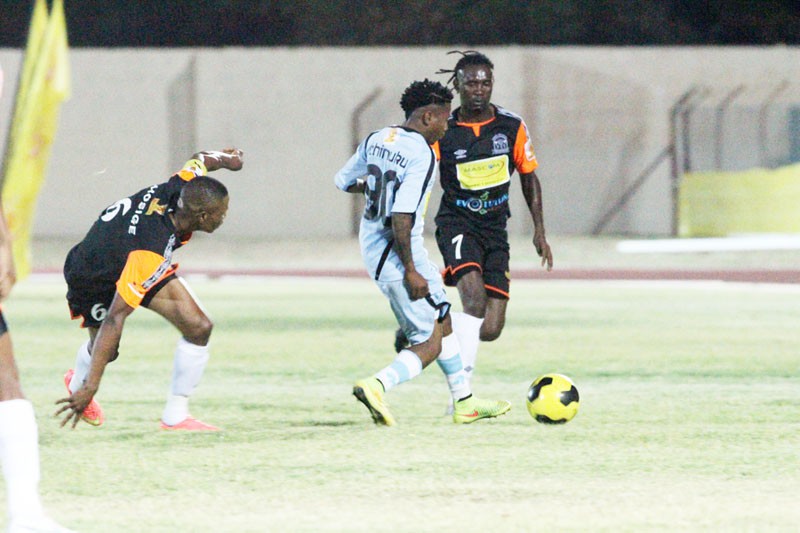 Man of the match, Tshegofatso Chimuku (in blue) taking on Orapa United players; Thabang Mosige and Ronald Chikomo PIC: KAGISO ONKATSWITSE