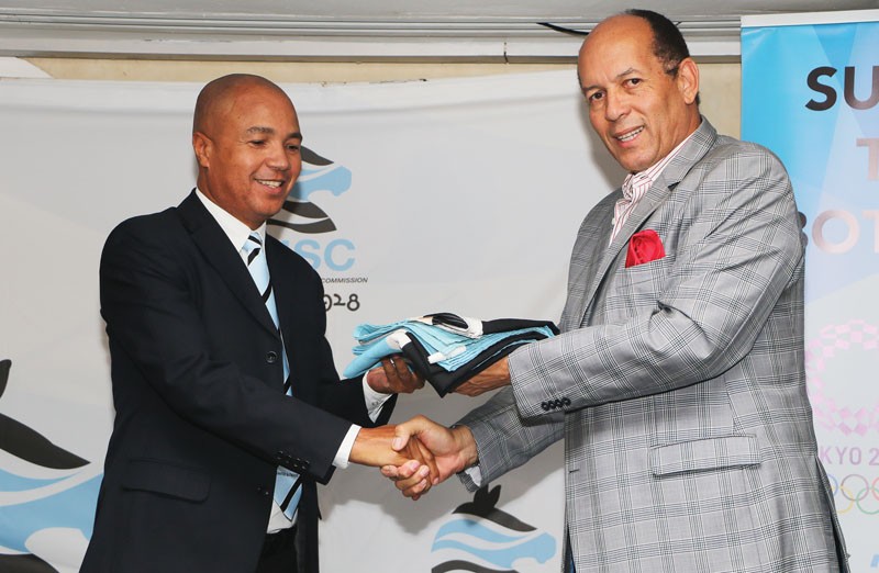 Minister Khama (right) hands over the flag to Chef de mission, Bobby Gaseitsiwe PIC: KENNEDY RAMOKONE