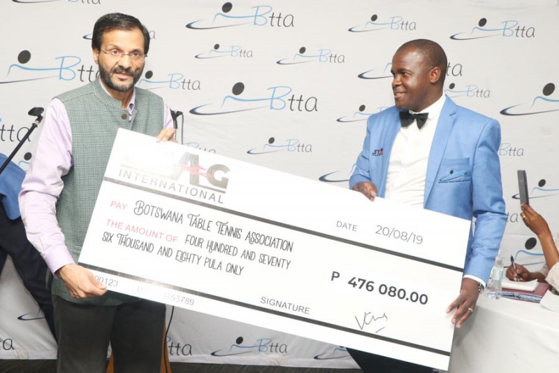 Satender Yadav handing the cheque to BTTA president Kudzanani Motswagole. PIC: MORERI SEJAKGOMO